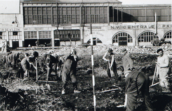 Beschrijving: Opgravingen aan het terrein langs de 1e Weenastraat, waar men op zoek is naar de grondvesten van het slot Weena. Op de achtergrond het station Hofplein. 